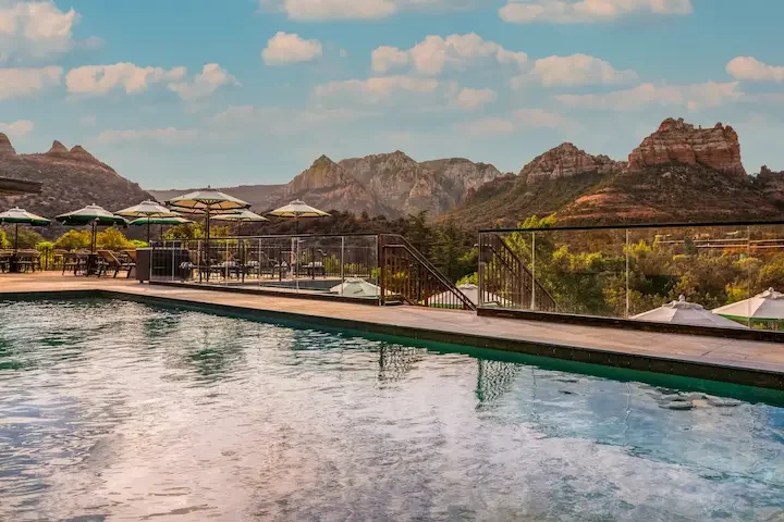 An outdoor swimming pool with mountain and red-rock views