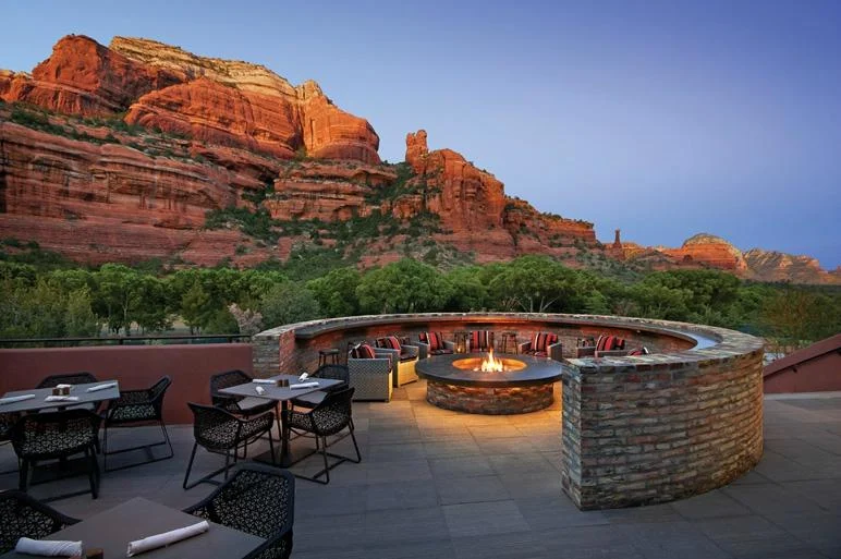 A terrace and circular fire pit beneath red cliffs