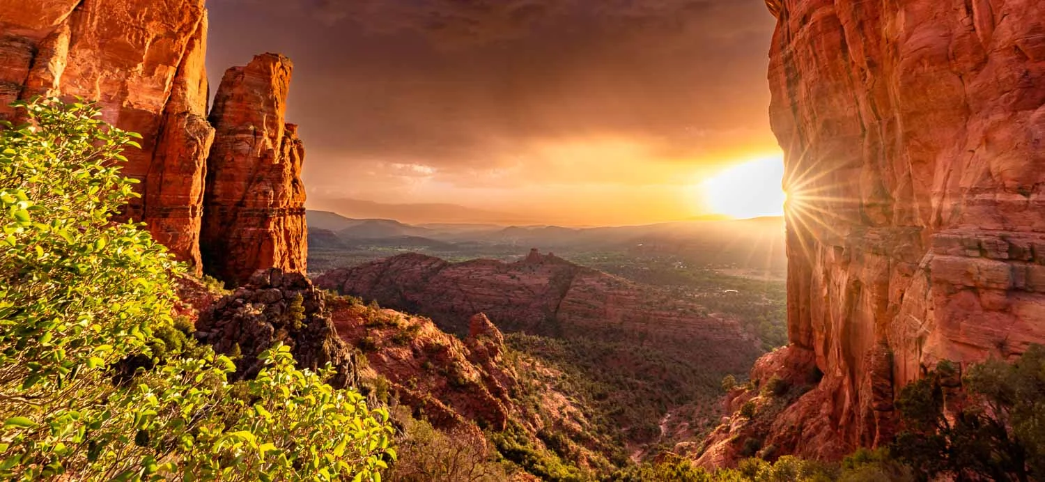 Sunlight entering a sandstone opening overlooking a desert valley