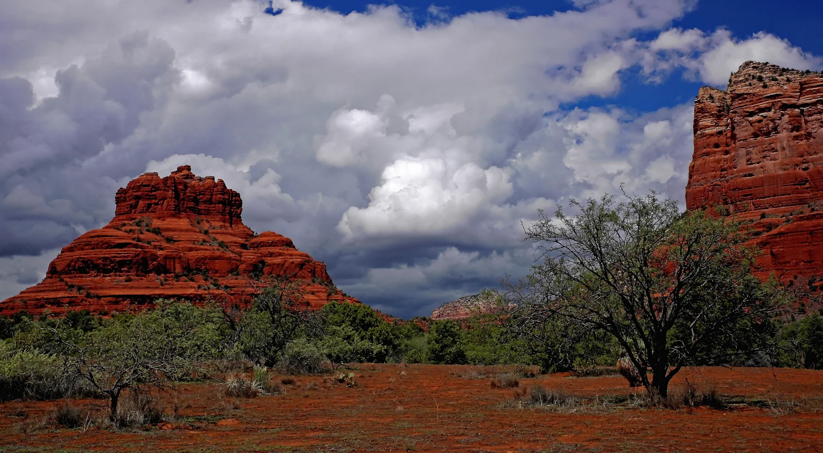 Bell Rock and neighboring red sandstone cliffs beneath clouds near Sedona