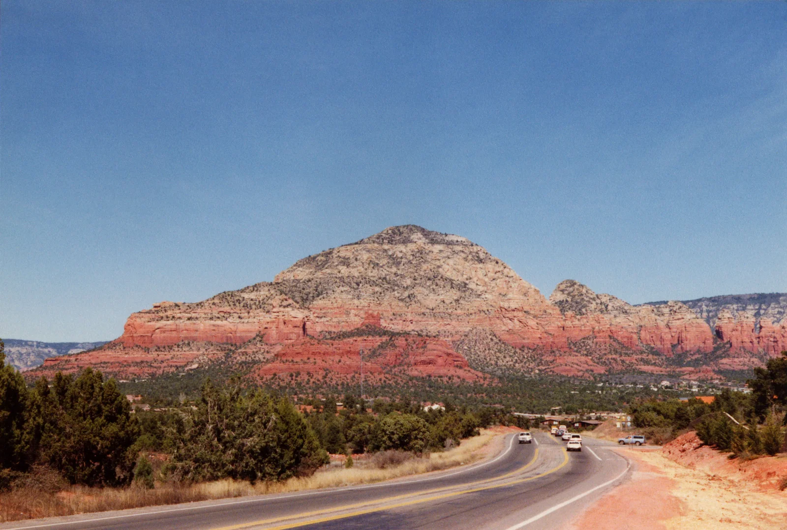 Red sandstone beneath a pale upper cliff beside a road into Sedona, photographed by Andrew Dunn in 1992