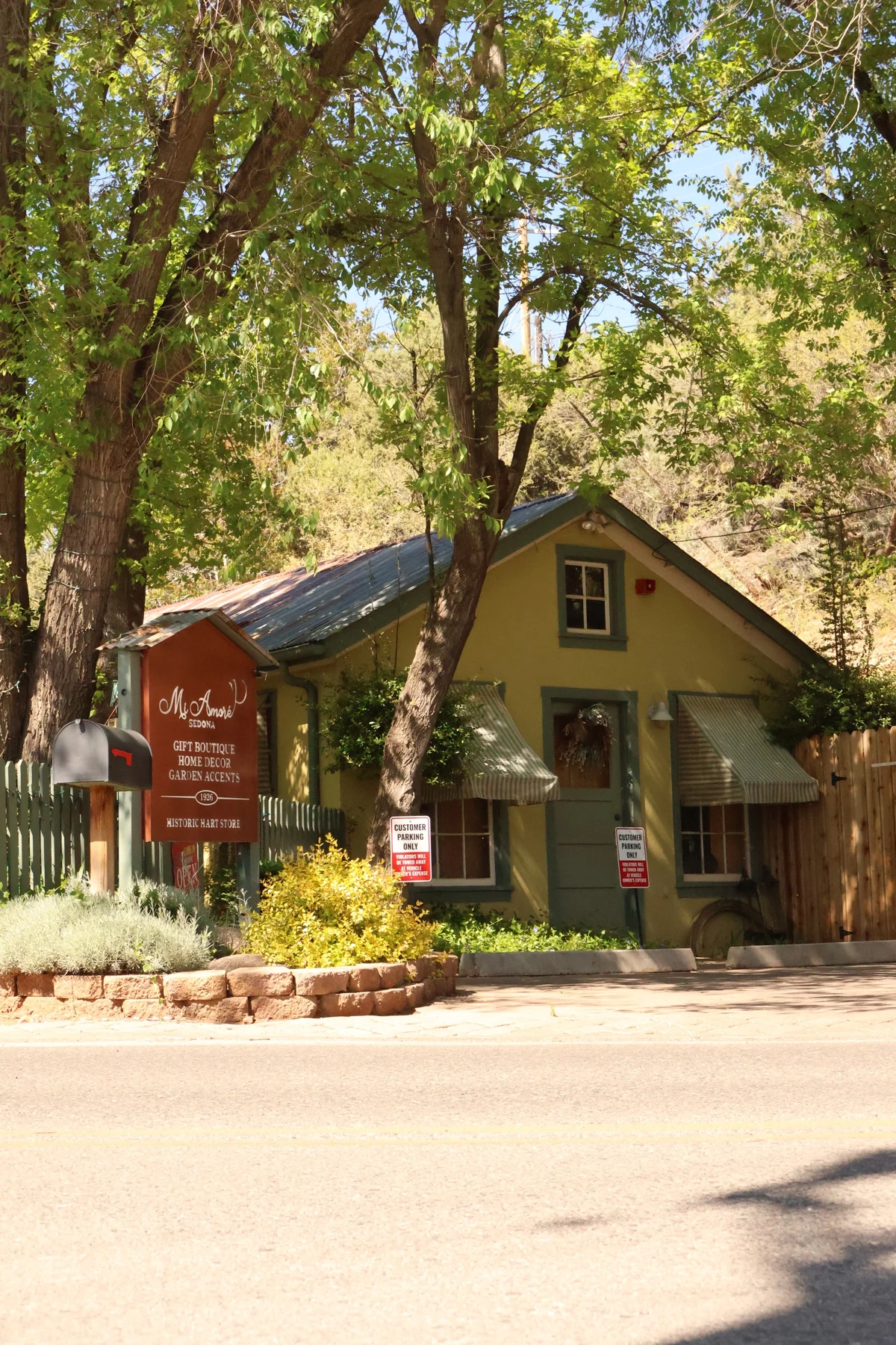 Mi Amoré Sedona's historic building and sign beneath leafy trees